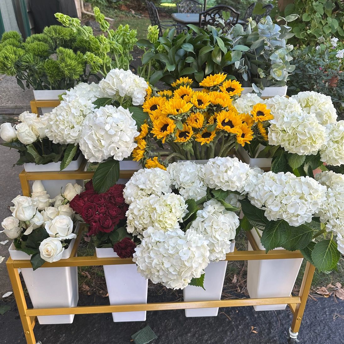Fresh flowers in white vases on the gold cart